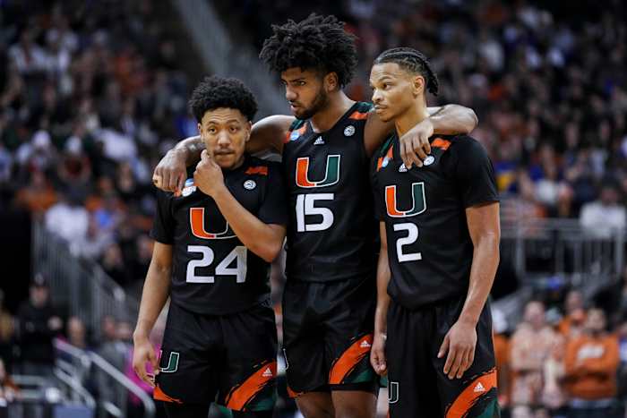 Nijel Pack (24), forward Norchad Omier (15), and guard Isaiah Wong (2) stand on the court together with their arms over each others shoulders